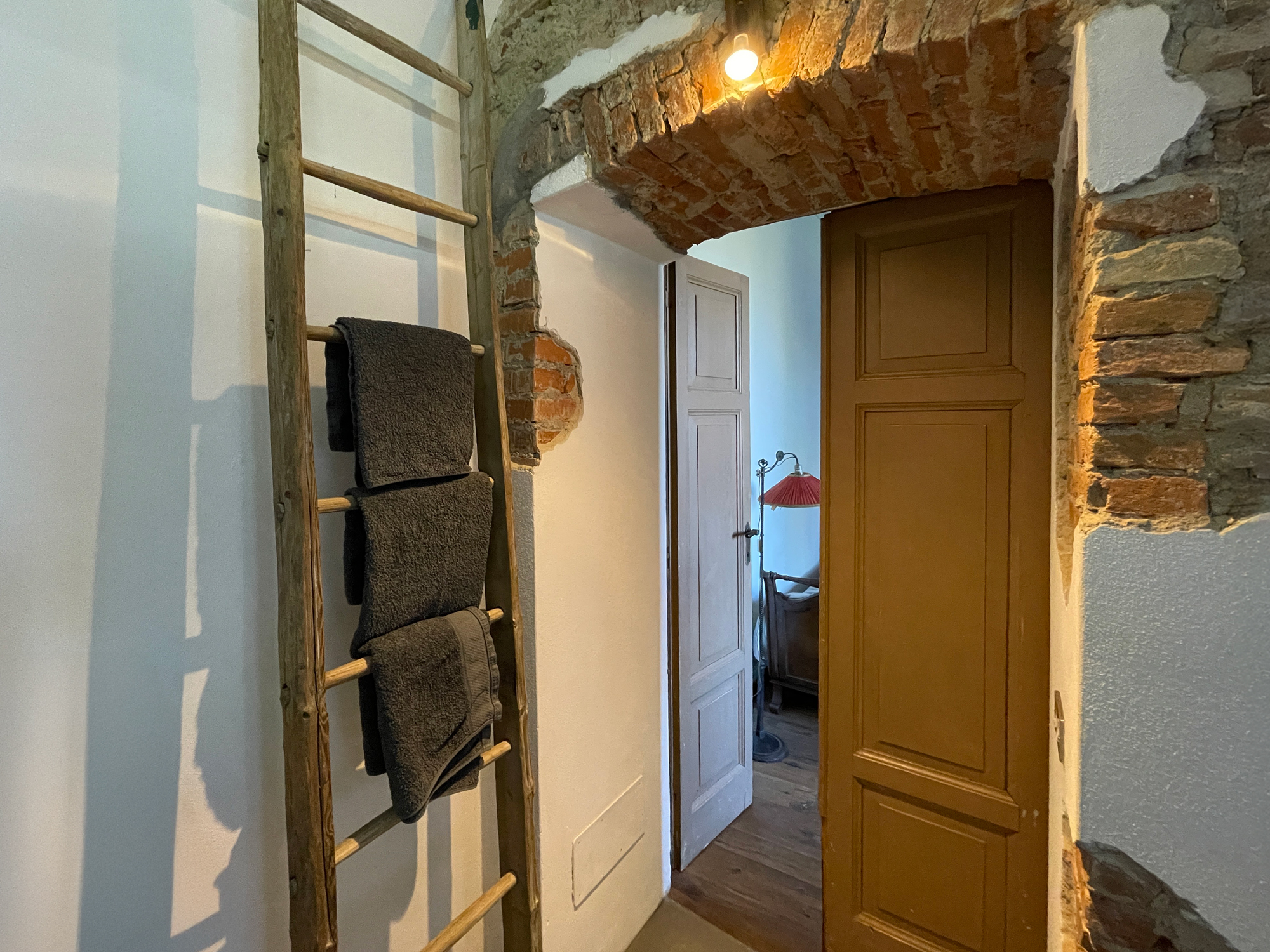 Porta in legno con cornice in pietra e dettagli decorativi di recupero