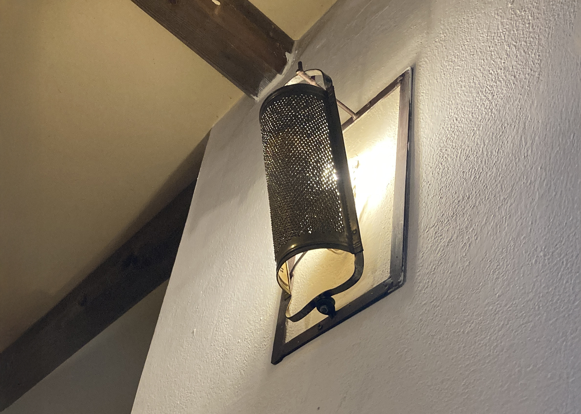 Lampada da parete realizzata con un oggetto metallico di recupero