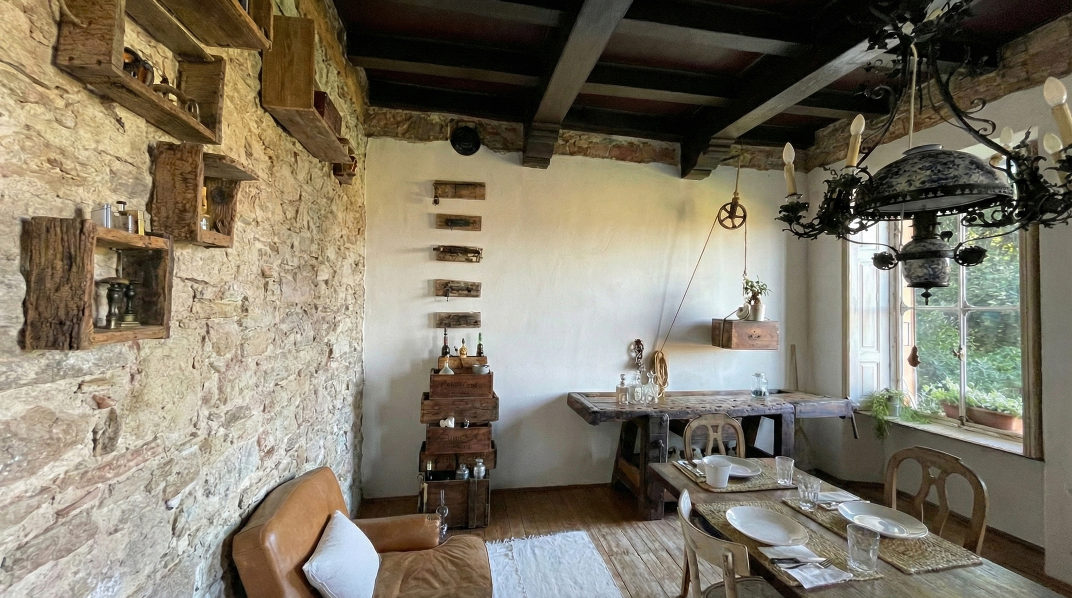 Zona pranzo con pareti in pietra, travi a vista e arredi in legno