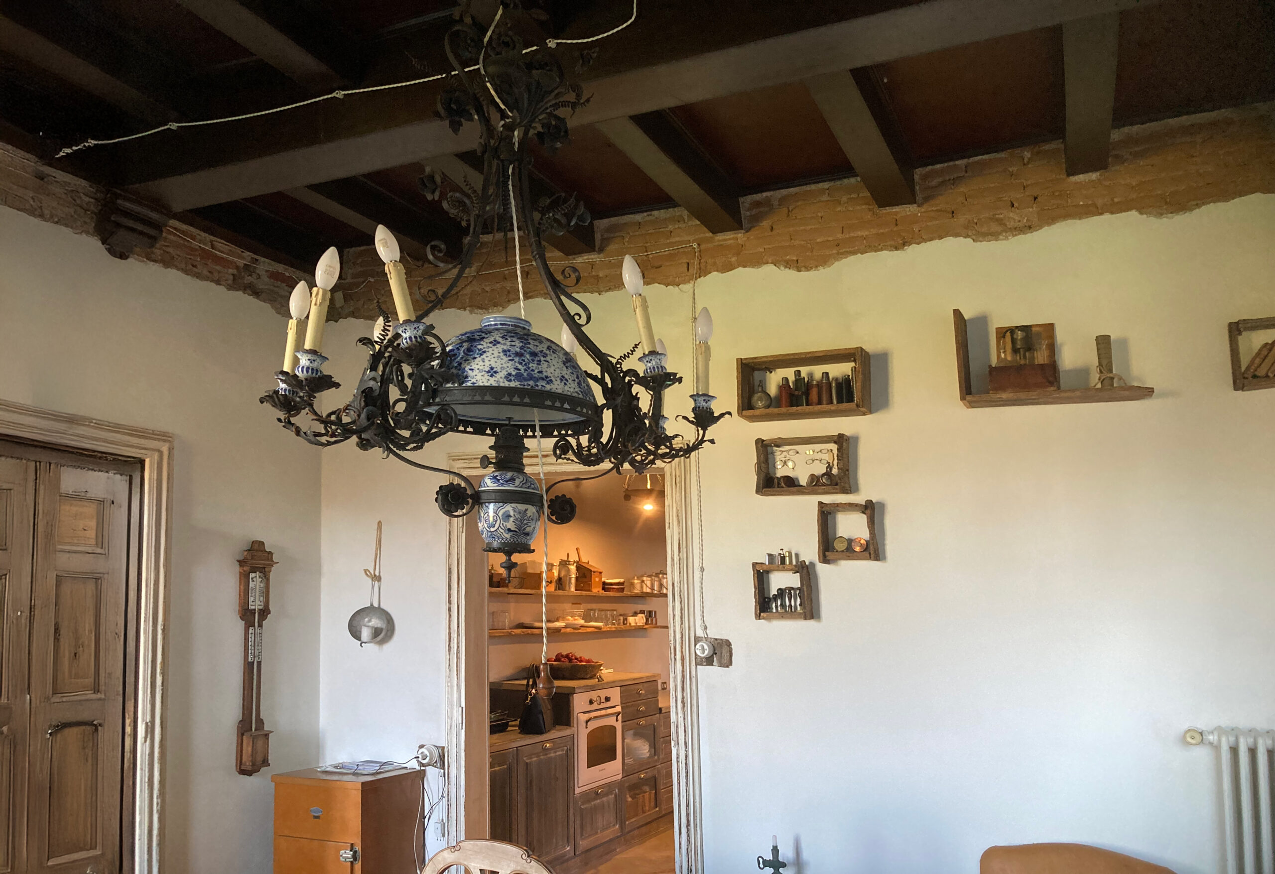 Lampadario rustico sotto travi a vista in una stanza con fotografie alla parete