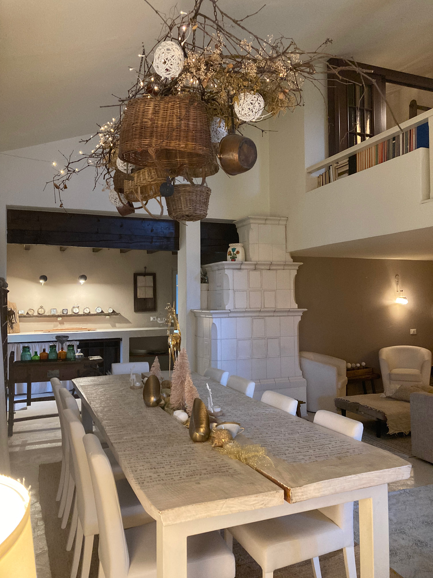 Tavolo da pranzo con sedie chiare sotto un lampadario decorativo