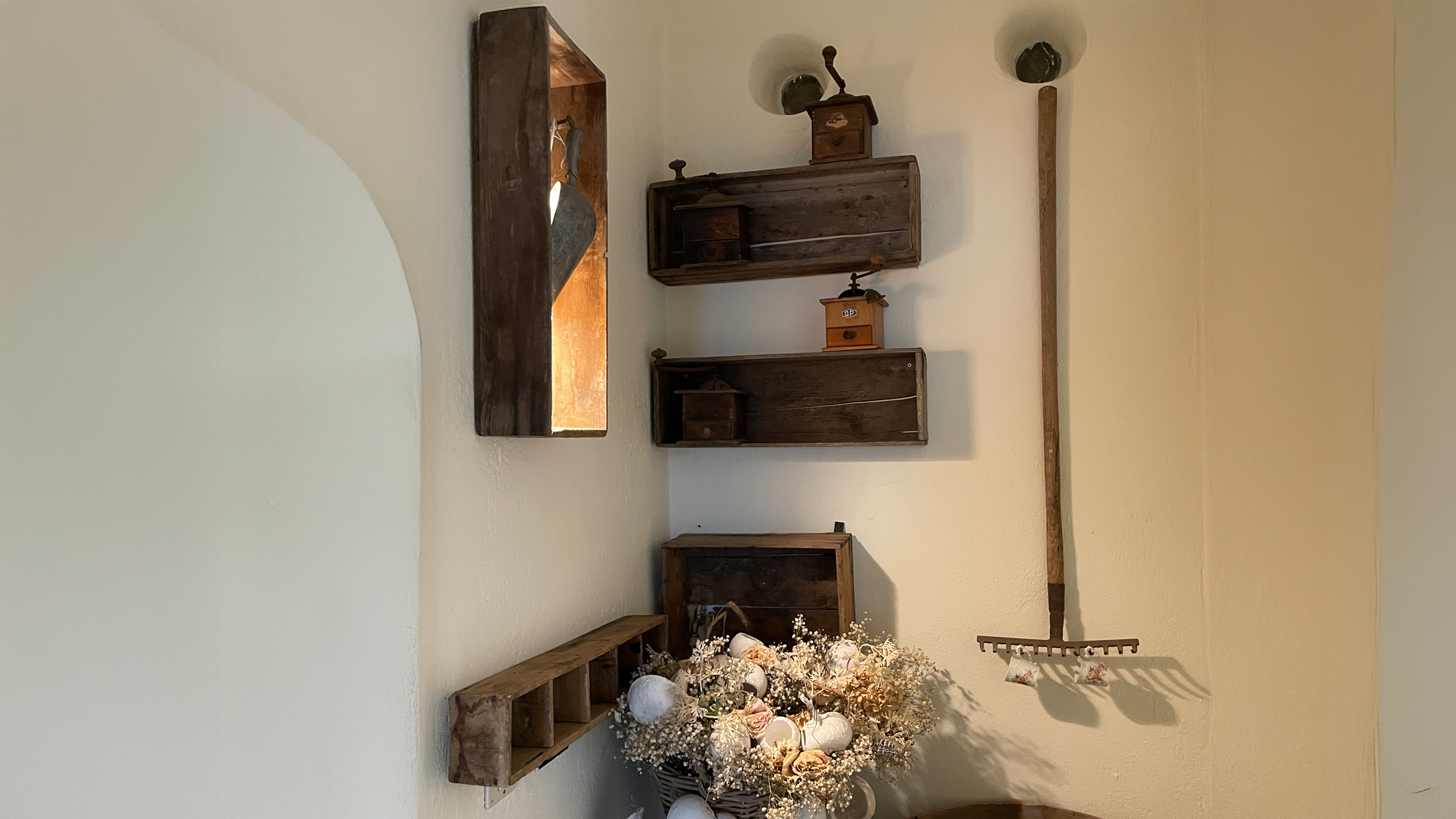 Composizione di specchi, legno e fiori su una parete chiara