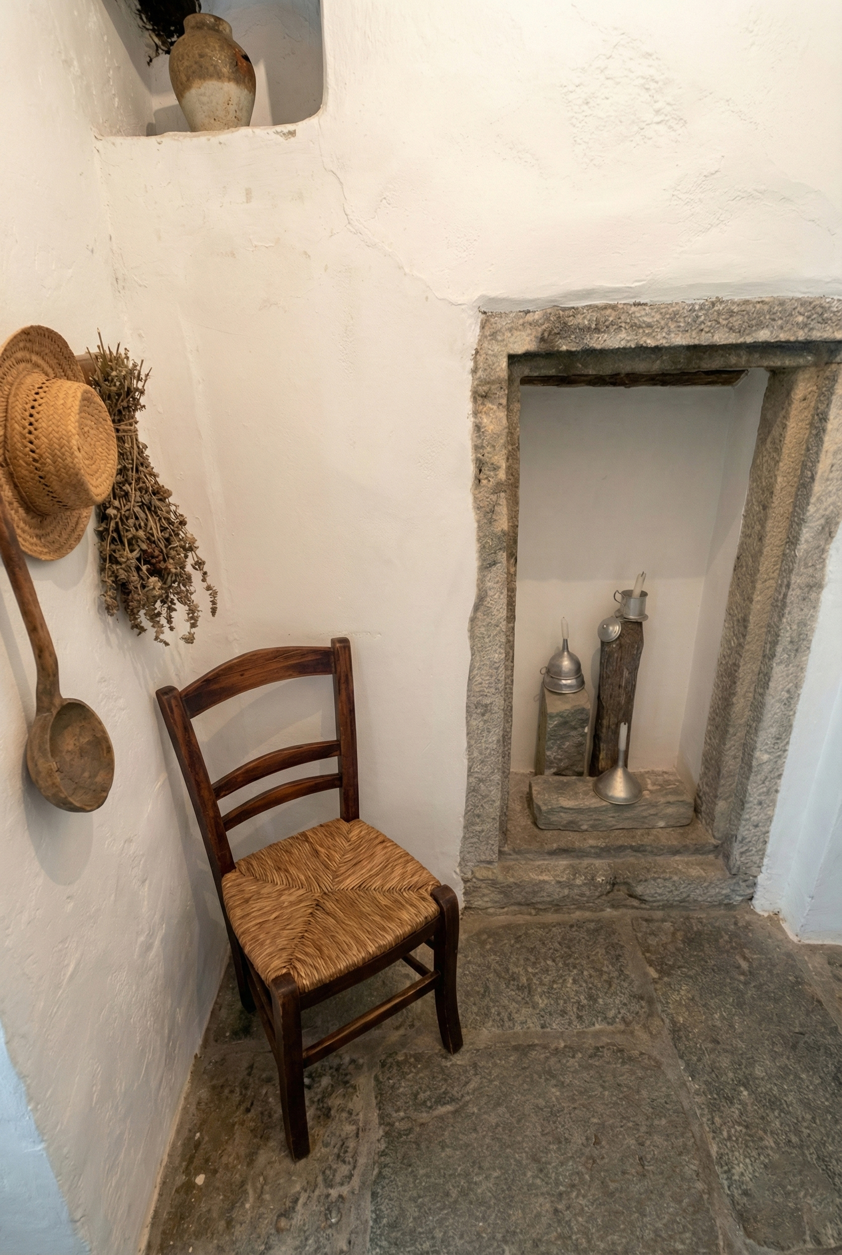 Sedia antica e cappelli accanto a una nicchia decorativa